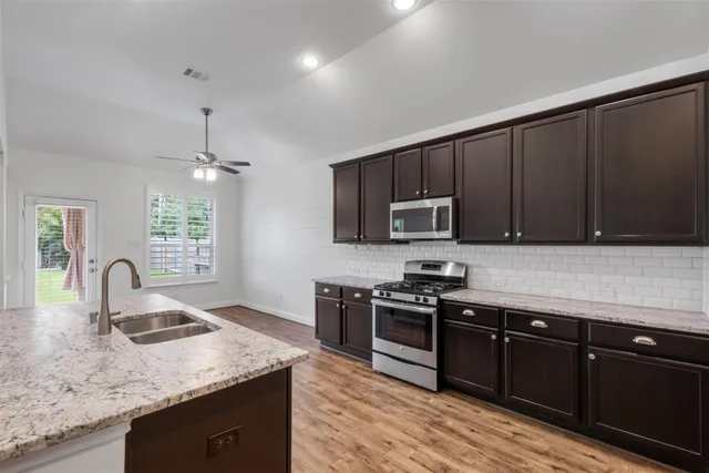 a kitchen with granite countertop stainless steel appliances and sink