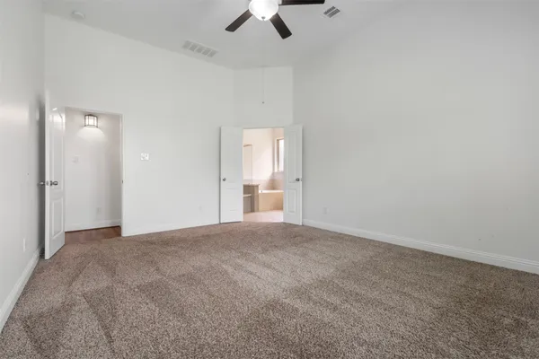 an empty room with a window and ceiling fan