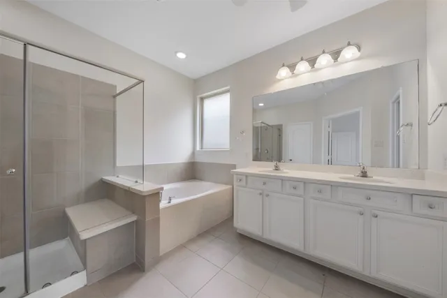 a spacious bathroom with a double vanity sink mirror and bathtub