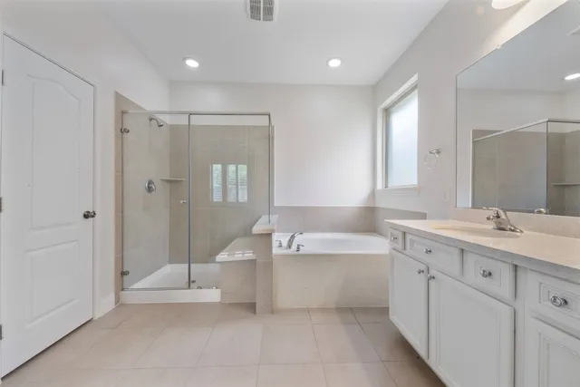 a spacious bathroom with a double vanity sink a mirror and a bathtub