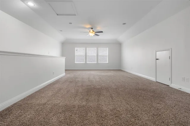an empty room with a window and ceiling fan