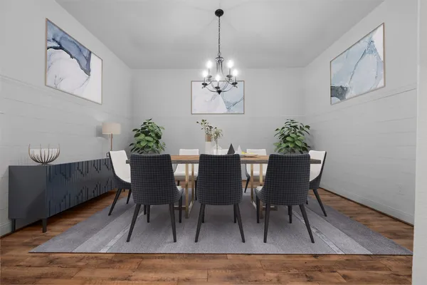 a view of a room with a chandelier fan and wooden floor