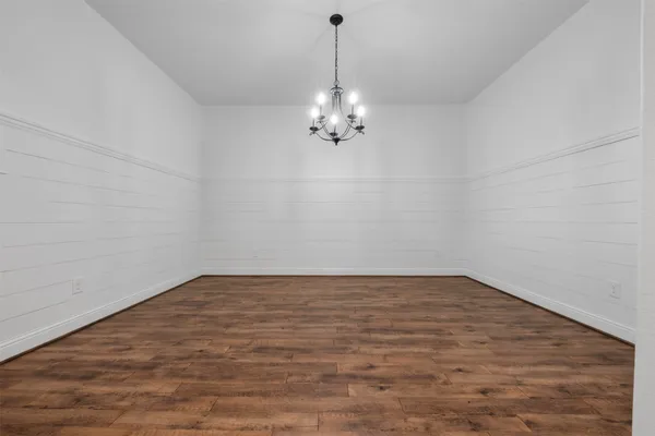 an empty room with windows fireplace and wooden floor