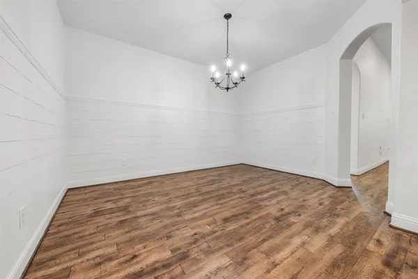 a view of a kitchen with furniture a ceiling fan and wooden floor