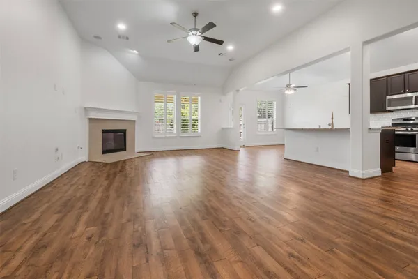 a view of empty room with wooden floor and fireplace
