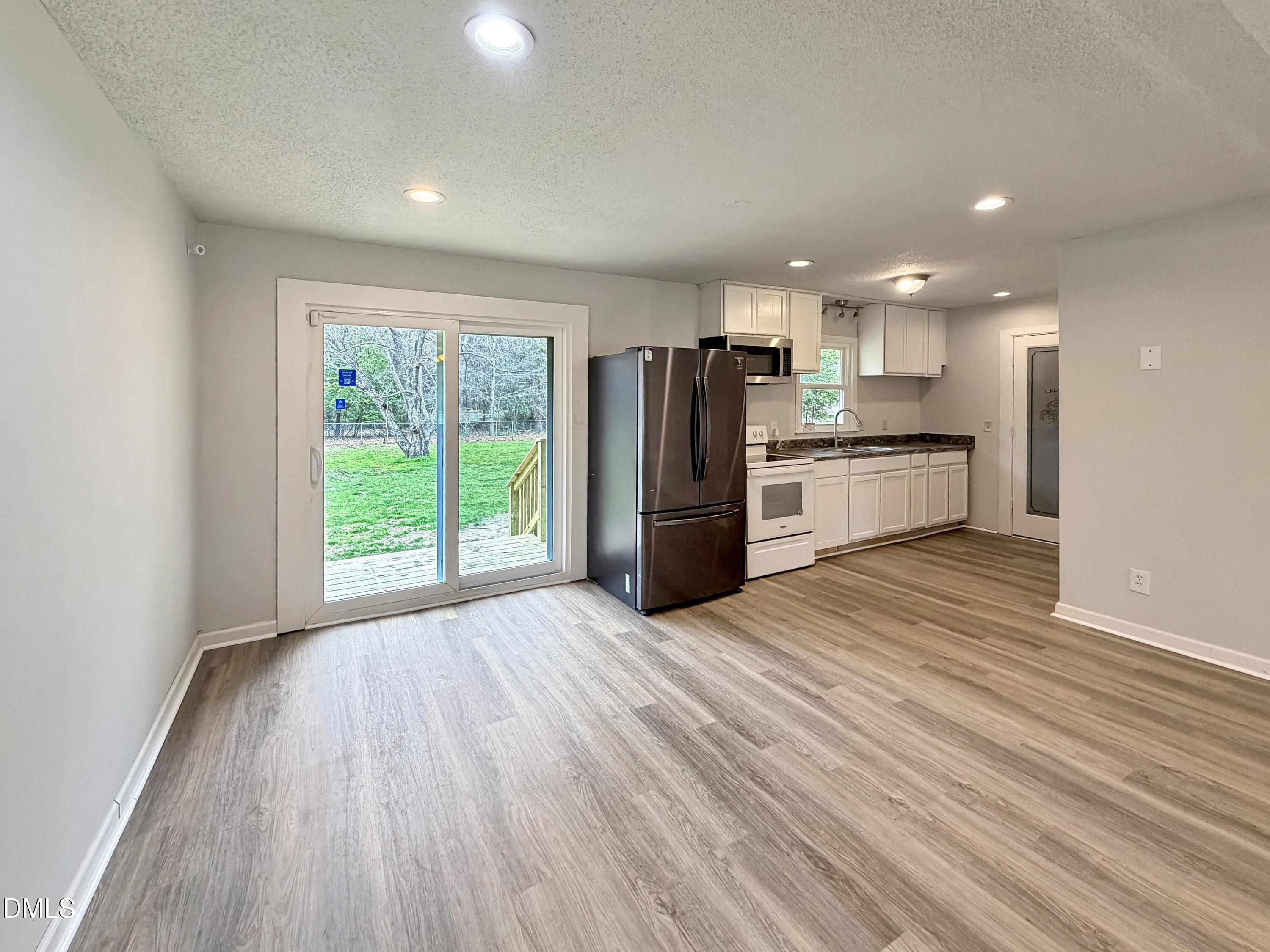 1181 McNeil Street Spring Lake, NC 28390 - Photo 7 of 18 a view of a kitchen with a refrigerator wooden floor and a window