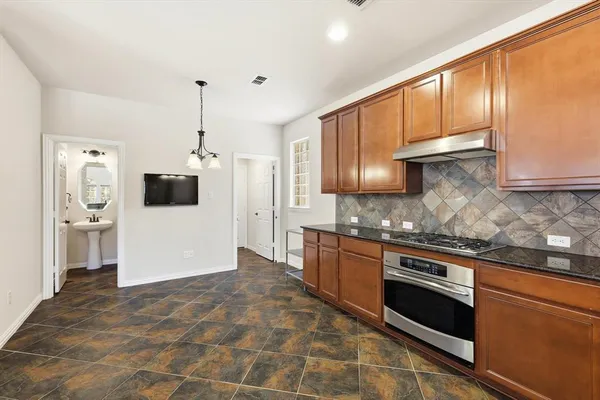 a kitchen with stainless steel appliances granite countertop a stove a sink and a microwave