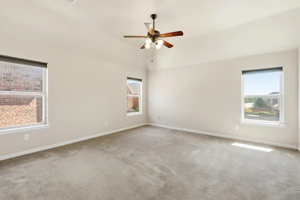 an empty room with a window and a fan