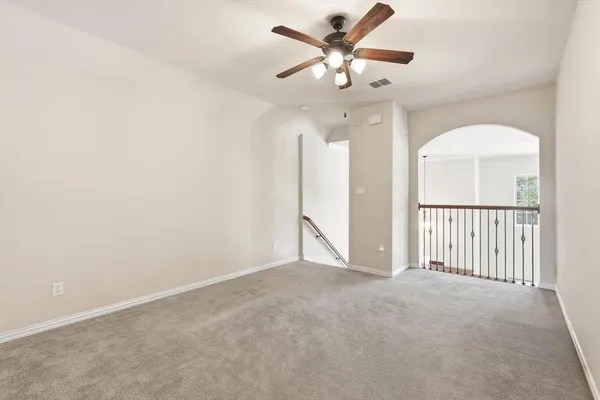 an empty room with chandelier fan