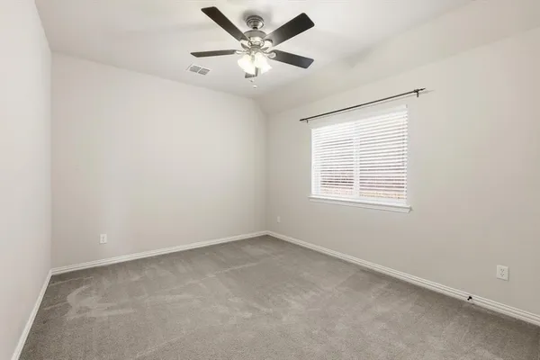an empty room with a window and a fan