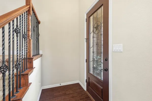a view of a hallway with wooden floor and entryway
