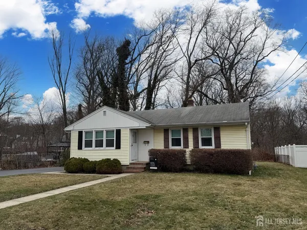 a front view of a house with yard porch and tree