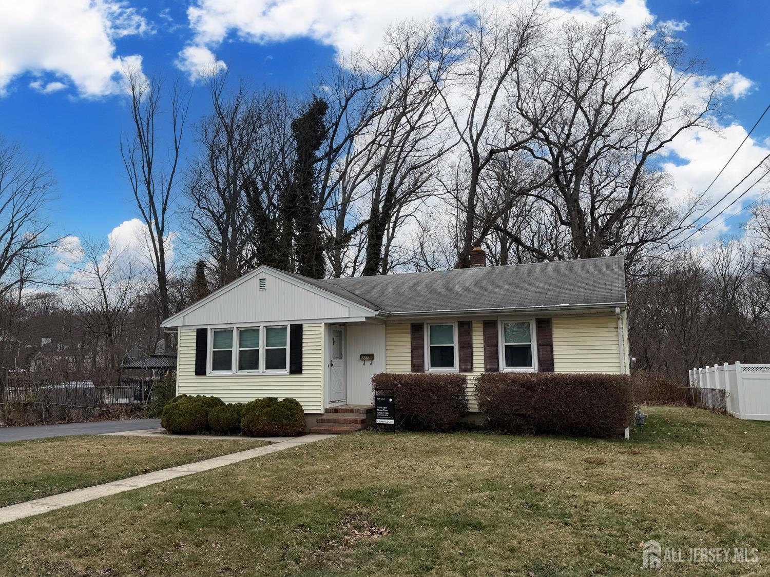 a front view of a house with yard porch and tree