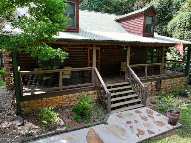 a view of a backyard with chairs and potted plants