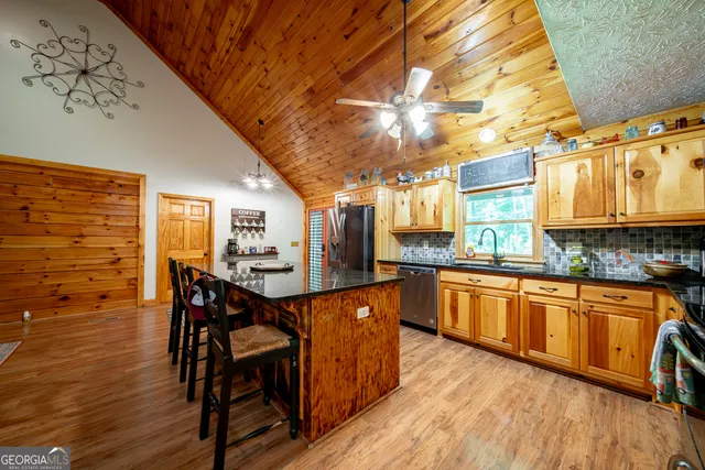 a kitchen with stainless steel appliances granite countertop wooden floors a stove and white cabinets