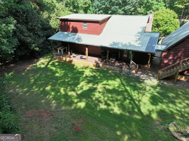 a view of a big yard with table and chairs under an umbrella