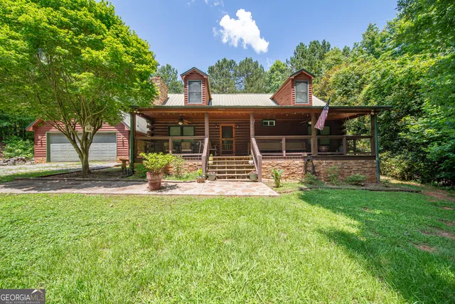 a view of a house with backyard and sitting area