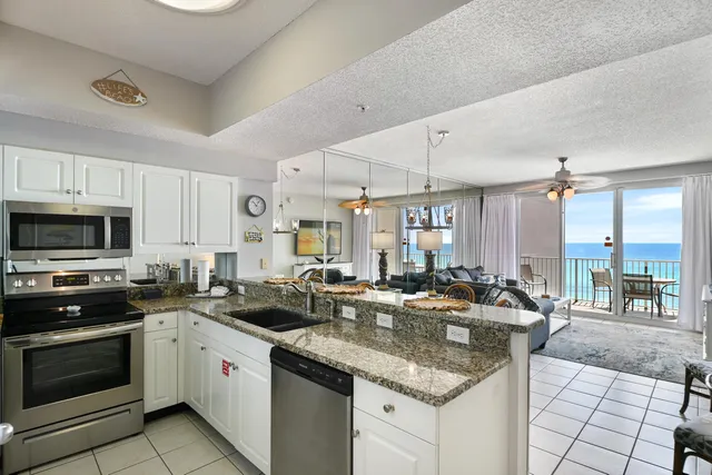 a kitchen with counter top space appliances and a view of living room