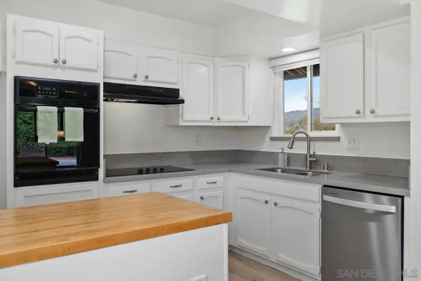a kitchen with granite countertop a sink and cabinets