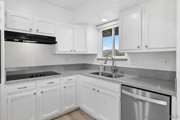a kitchen with white cabinets and a sink