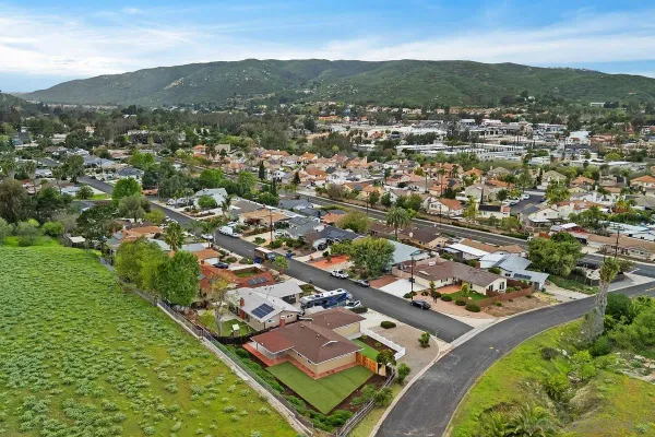 an aerial view of residential houses with outdoor space and trees