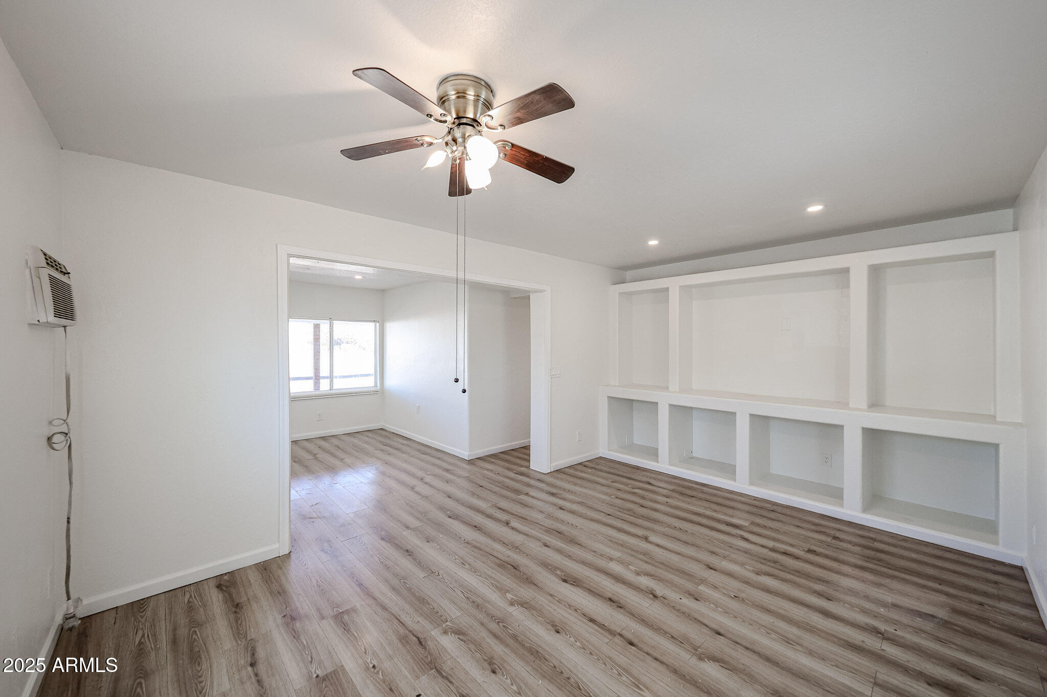 2839 East Marco Polo Road Phoenix, AZ 85050 - Photo 11 of 43 a view of an empty room with a window and wooden floor