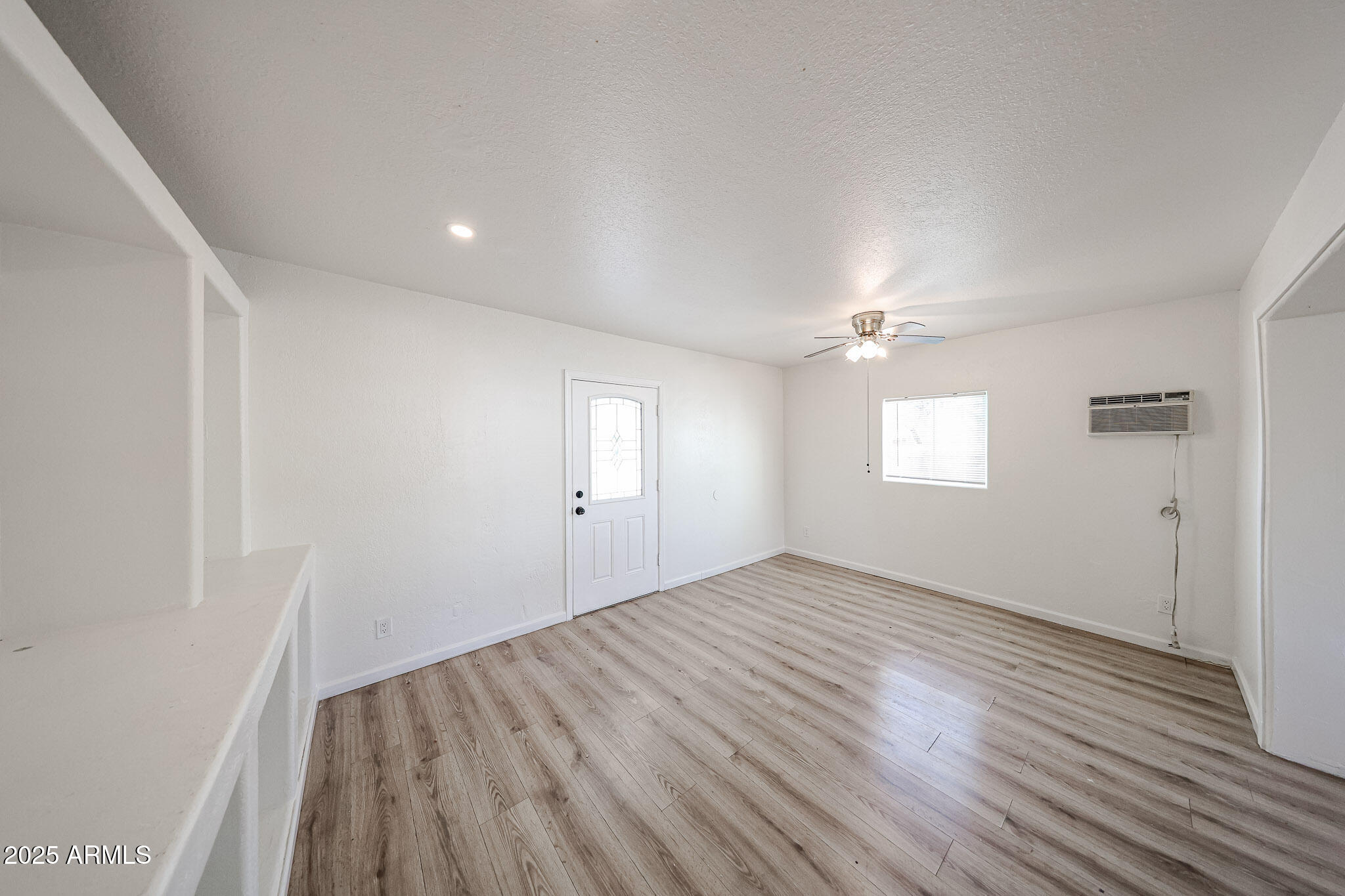 2839 East Marco Polo Road Phoenix, AZ 85050 - Photo 13 of 43 an empty room with wooden floor cabinet and windows