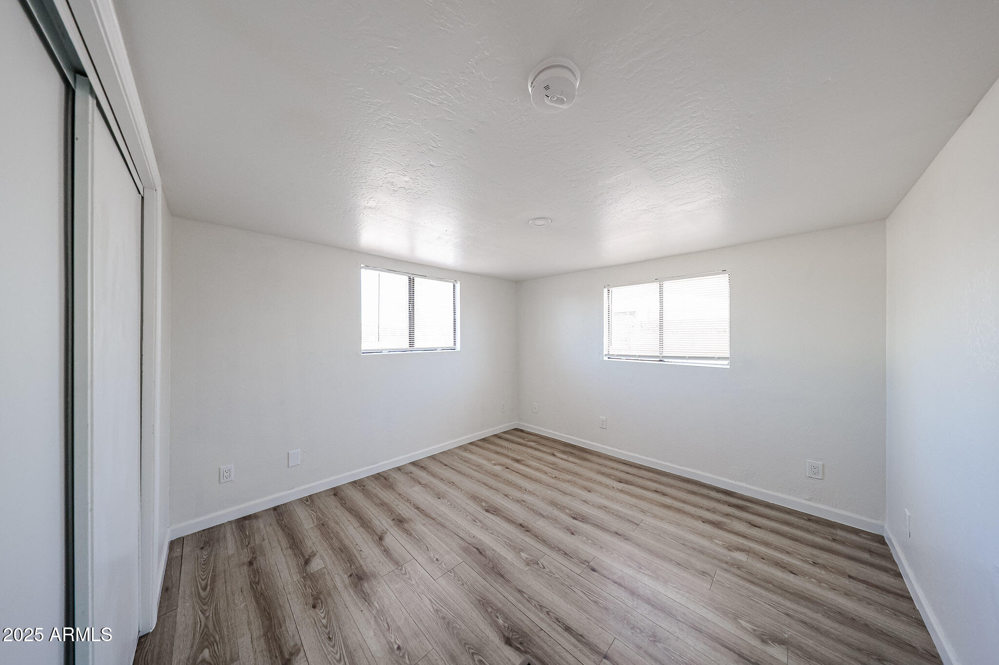 2839 East Marco Polo Road Phoenix, AZ 85050 - Photo 17 of 43 an empty room with wooden floor and windows