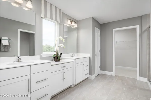 a bathroom with double sink and a mirror