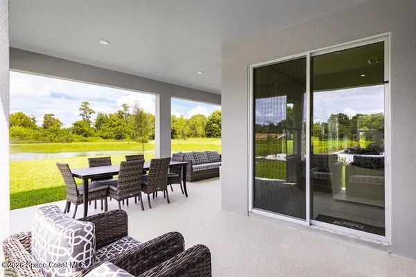 a dining room with furniture large windows and a rug