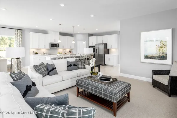 a living room with furniture and a view of kitchen