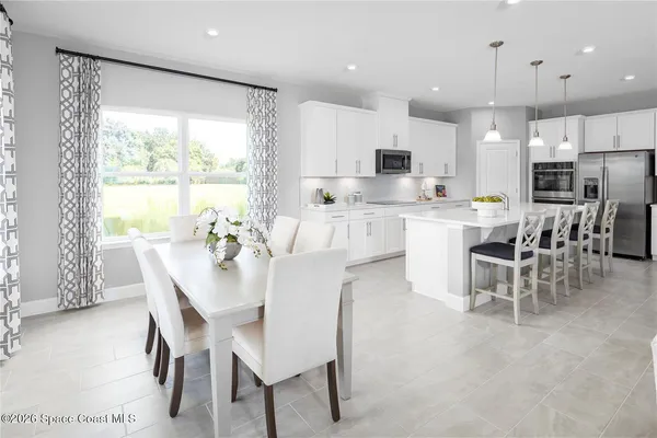 a large kitchen with a table and chairs