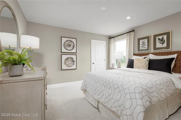 a bedroom with a bed and a potted plant