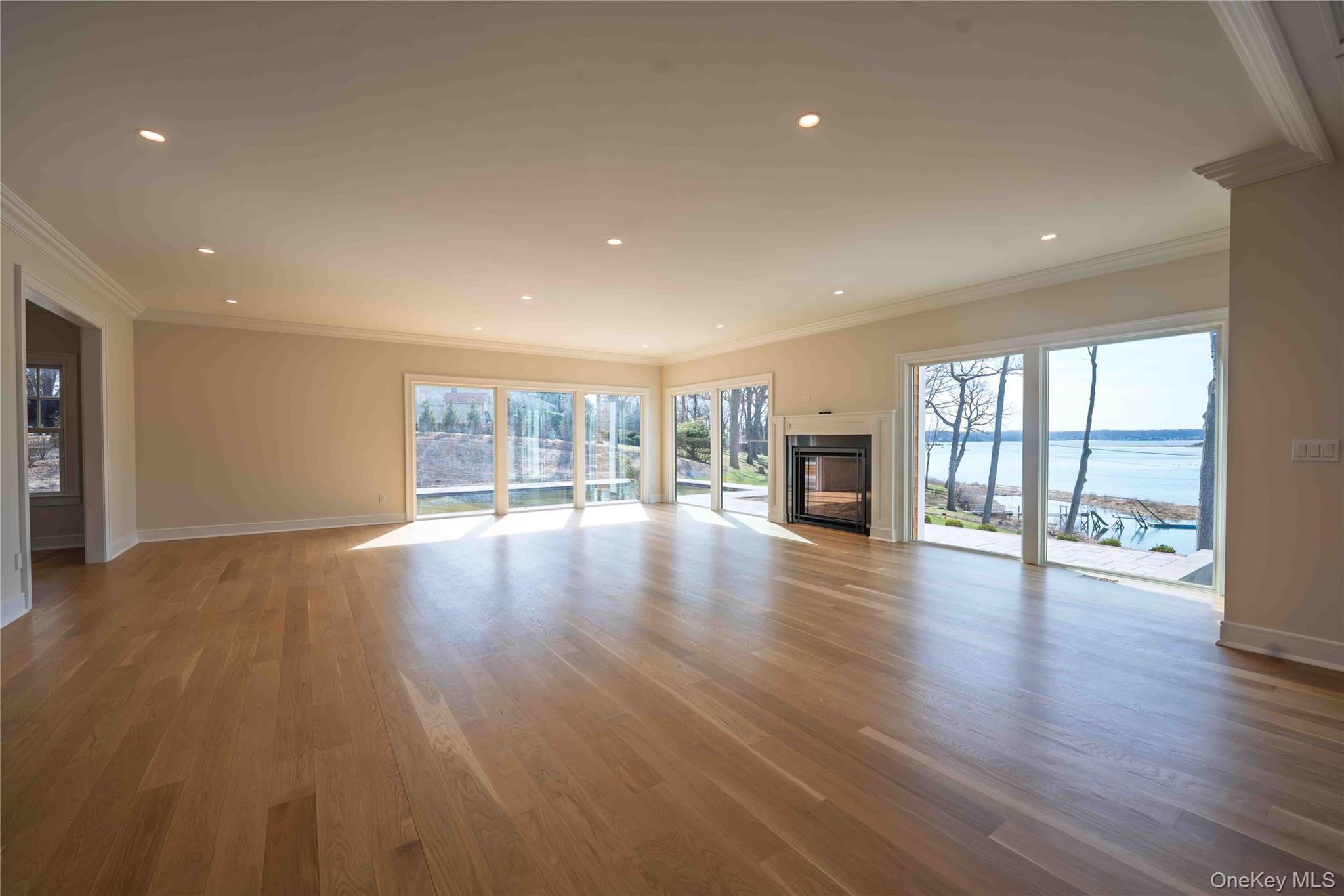 106 Cove Road Northport, NY 11768 - Photo 14 of 49 an empty room with wooden floor and fireplace
