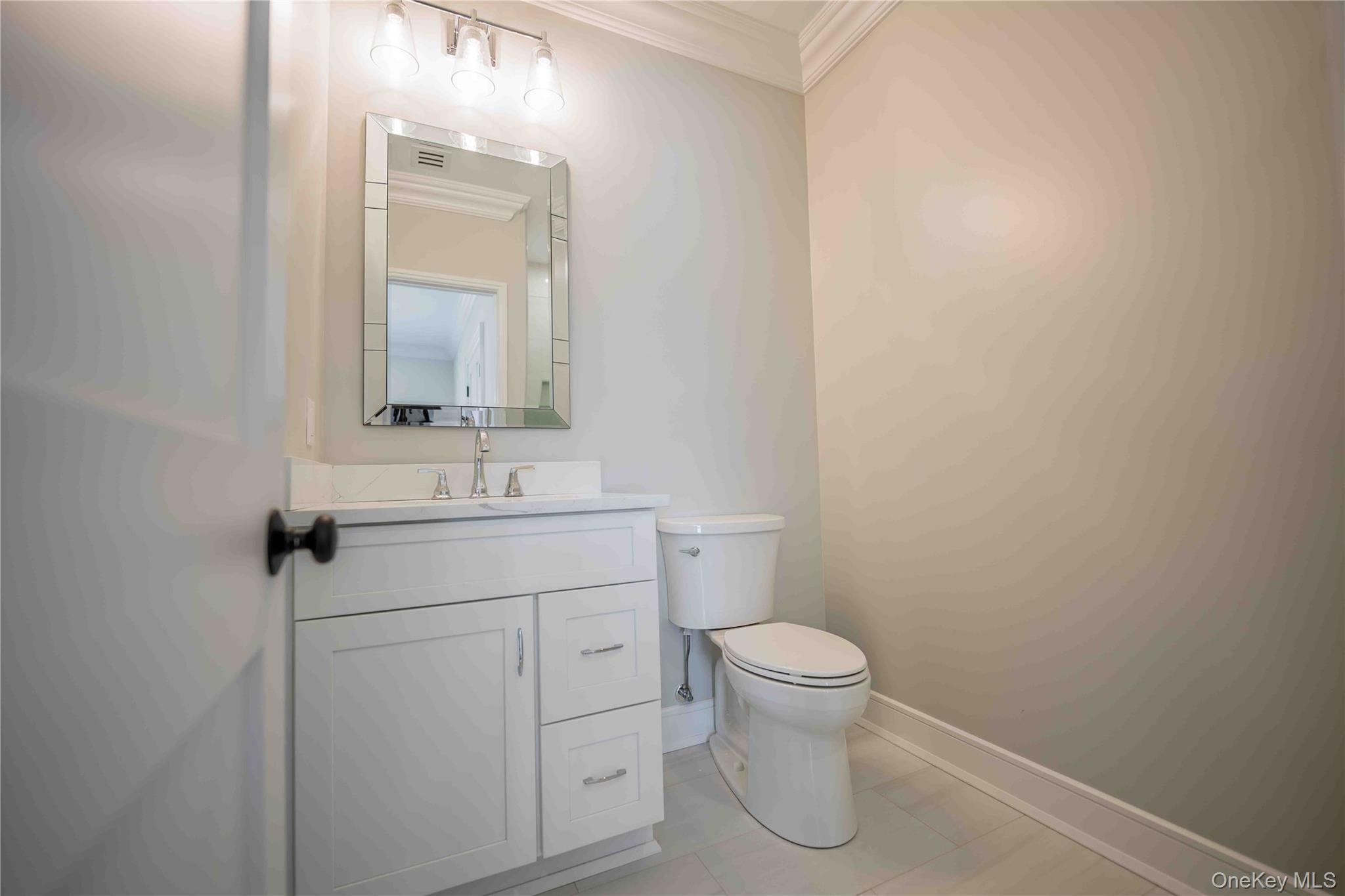 106 Cove Road Northport, NY 11768 - Photo 33 of 49 a bathroom with a toilet sink vanity and mirror
