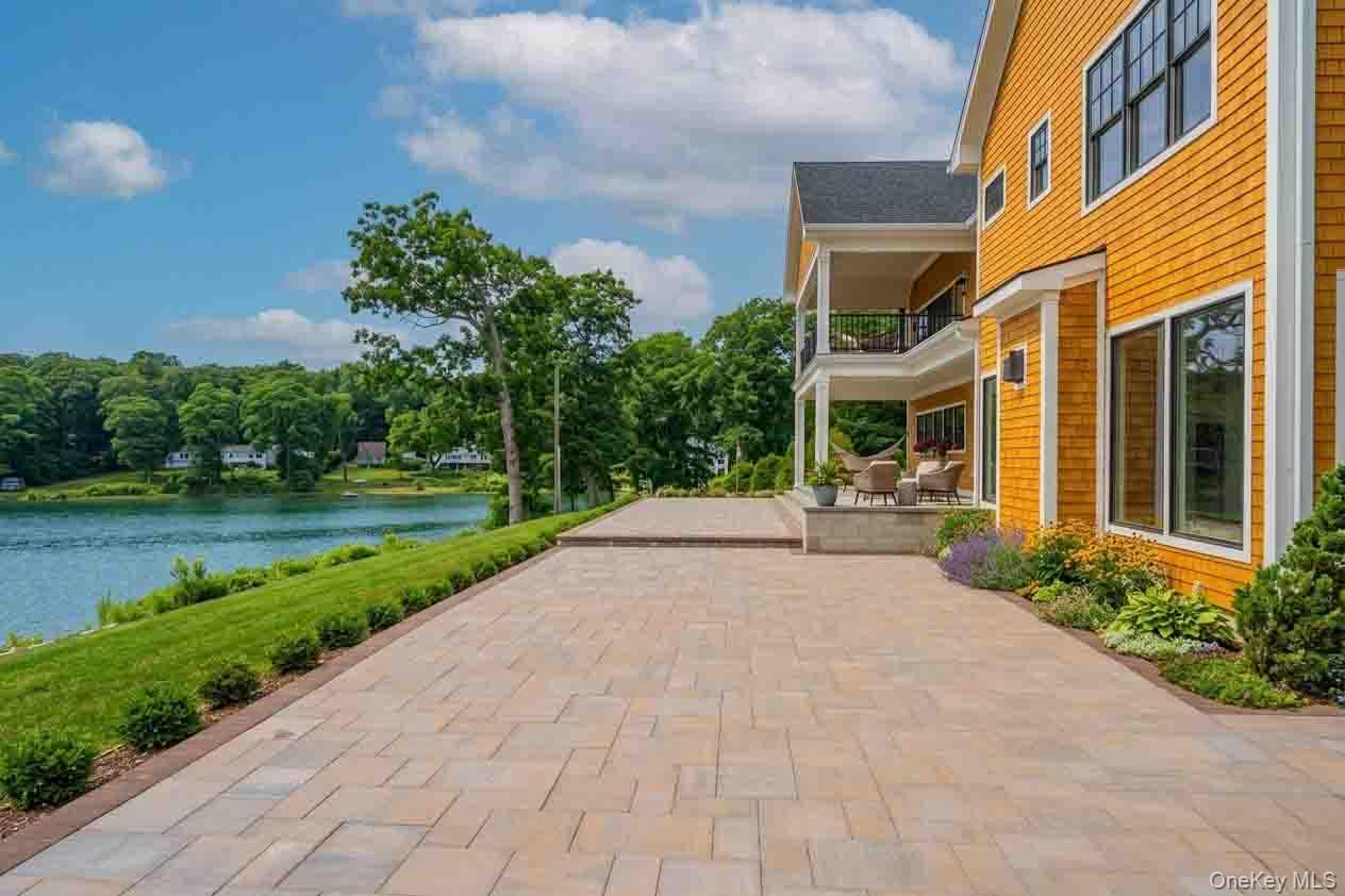 106 Cove Road Northport, NY 11768 - Photo 40 of 49 a view of a brick house with a yard and plants