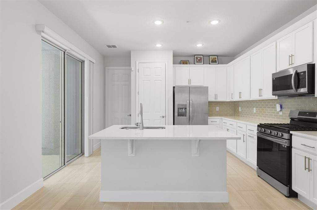 269 Platform Lane DeBary, FL 32713 - Photo 13 of 41 a large kitchen with stainless steel appliances granite countertop a stove a sink and a refrigerator