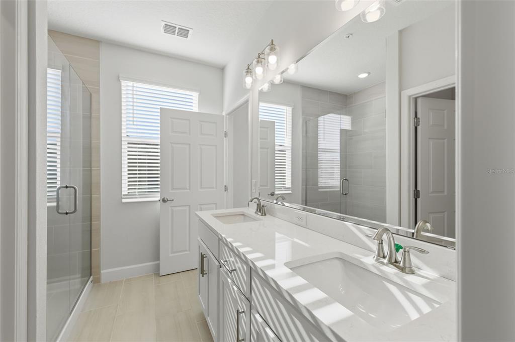 269 Platform Lane DeBary, FL 32713 - Photo 26 of 41 a bathroom with a granite countertop sink a large mirror and a shower