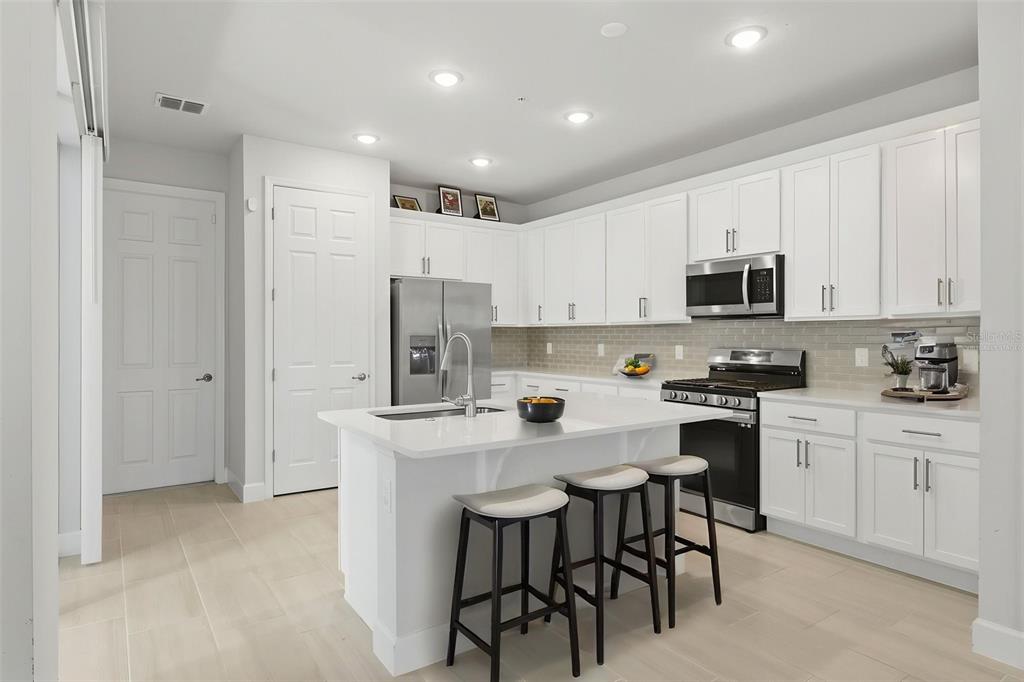 269 Platform Lane DeBary, FL 32713 - Photo 6 of 41 a kitchen with stainless steel appliances granite countertop a stove a sink a refrigerator a white table and chairs