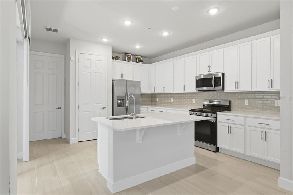 269 Platform Lane DeBary, FL 32713 - Photo 7 of 41 a kitchen with stainless steel appliances granite countertop a stove top oven a sink and a refrigerator