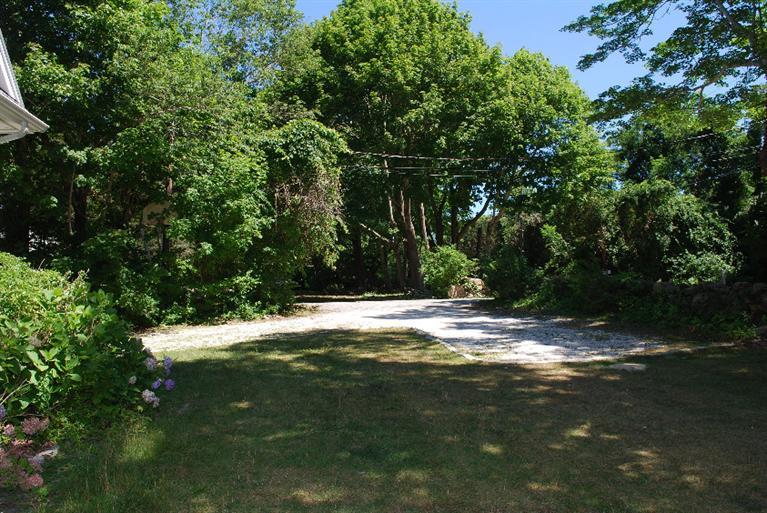 41 Chapoquoit Road Falmouth, MA 02540 - Photo 6 of 19 a view of a yard with plants and large trees