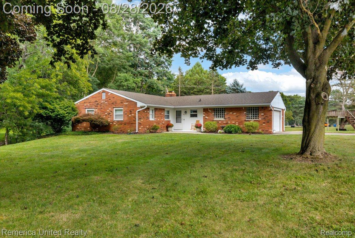 3687 Van Amberg Road Brighton, MI 48114 - Photo 45 of 56 Brick exterior with white trim, attached garage, and mature landscaping
