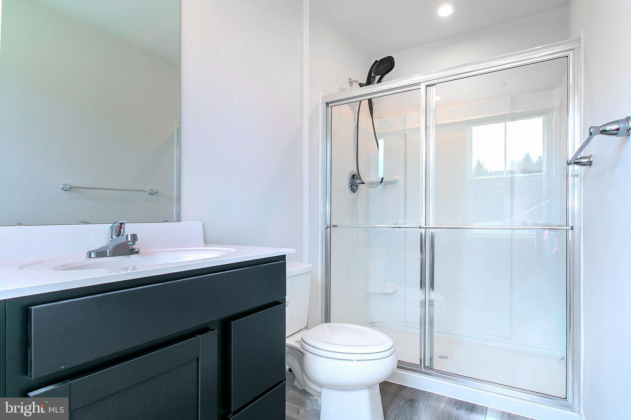 2616 High Point Drive Culpeper, VA 22701 - Photo 27 of 40 a bathroom with a sink toilet a mirror and shower
