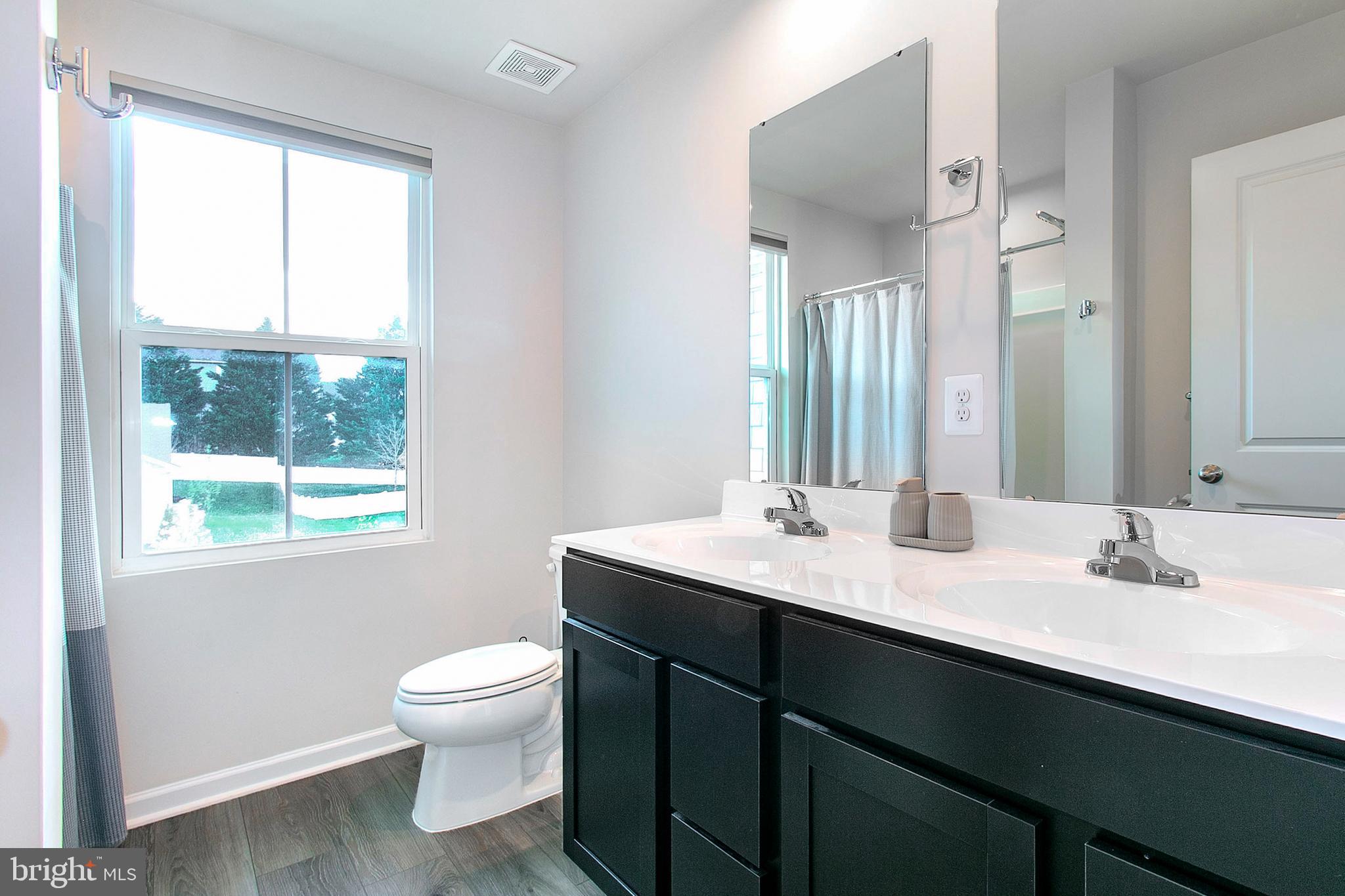 2616 High Point Drive Culpeper, VA 22701 - Photo 34 of 40 a bathroom with a granite countertop sink toilet a large mirror and a window