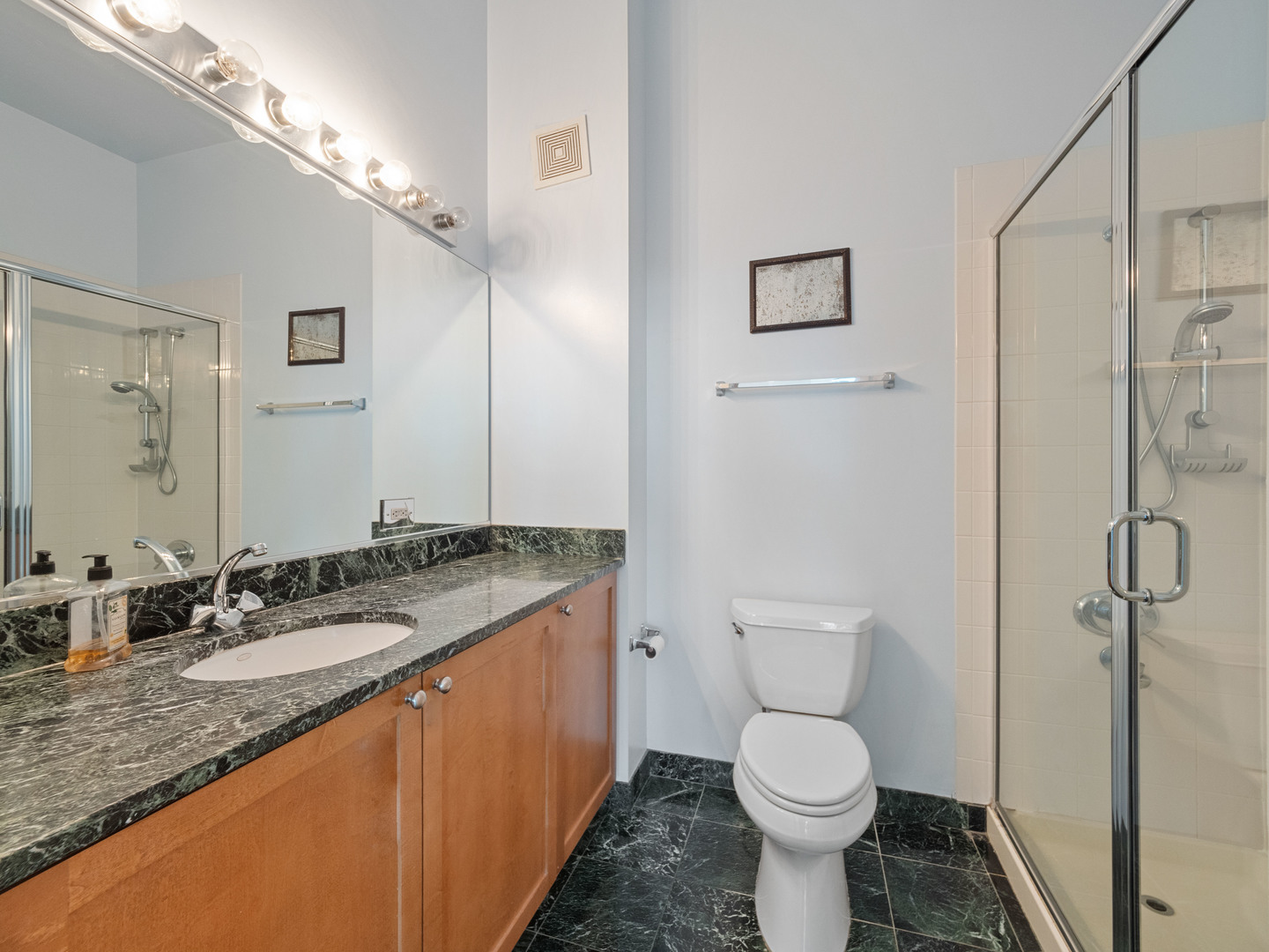 321 South Sangamon Street, Unit 905 Chicago, IL 60607 - Photo 28 of 36 a bathroom with a granite countertop toilet sink and mirror