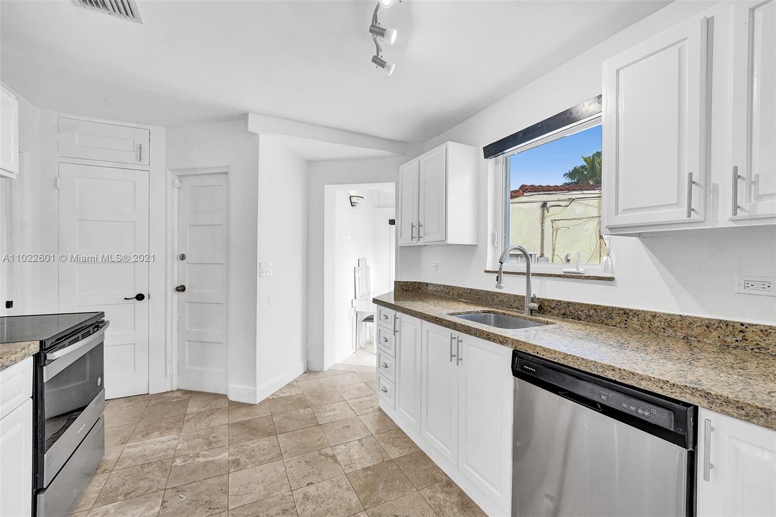 4717 Alton Road Miami Beach, FL 33140 - Photo 16 of 59 a kitchen with granite countertop a sink stove and cabinets