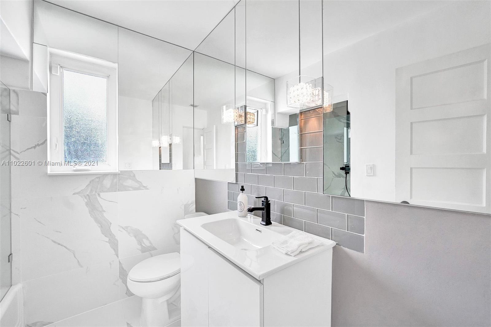 4717 Alton Road Miami Beach, FL 33140 - Photo 26 of 59 a bathroom with a sink toilet vanity and shower