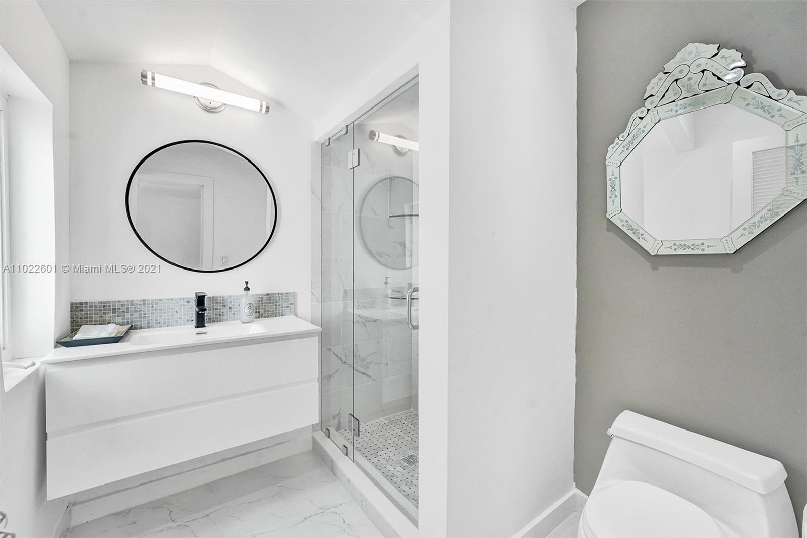 4717 Alton Road Miami Beach, FL 33140 - Photo 35 of 59 a bathroom with a sink mirror and toilet