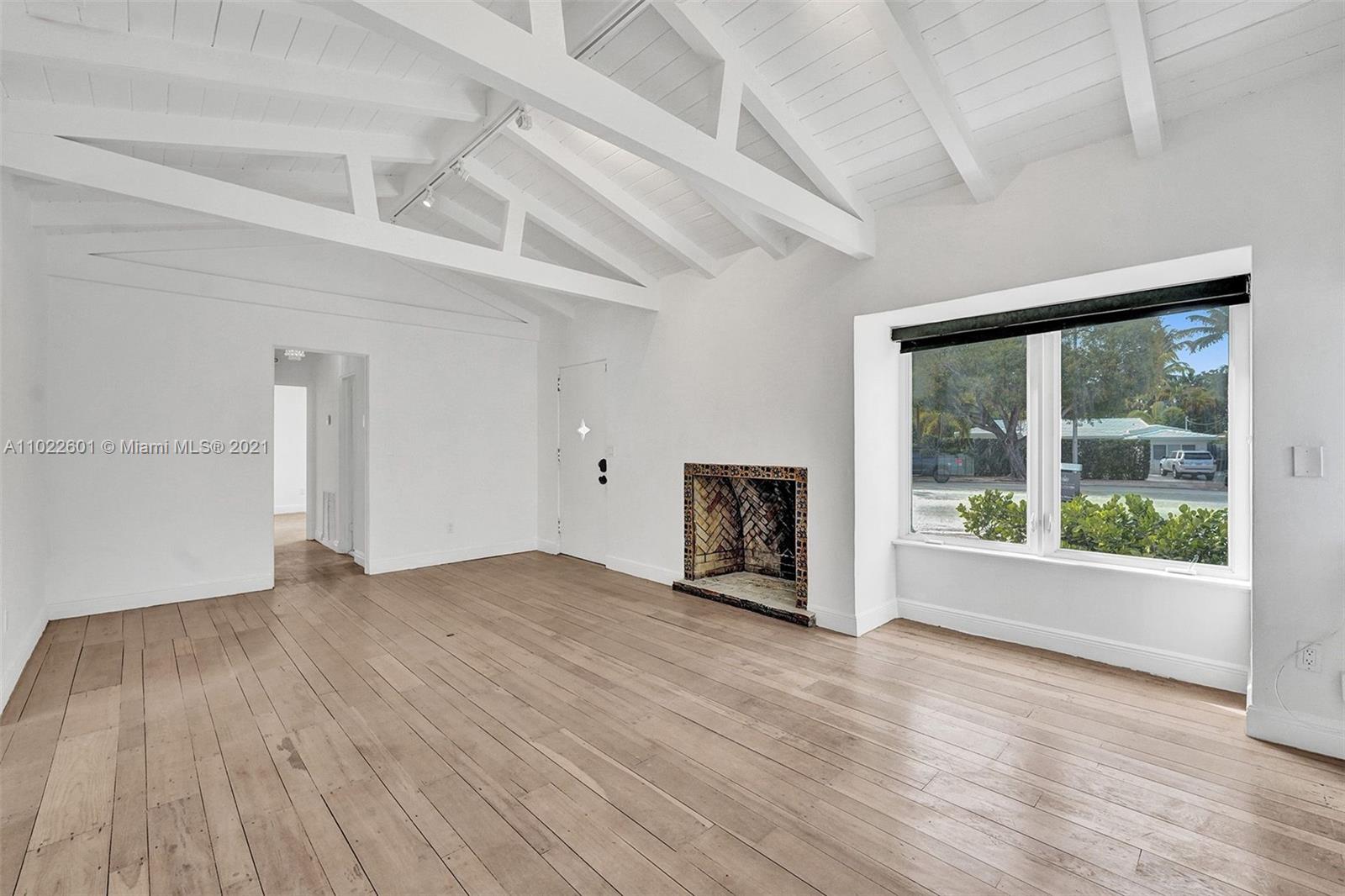 4717 Alton Road Miami Beach, FL 33140 - Photo 48 of 59 an empty room with wooden floor and windows