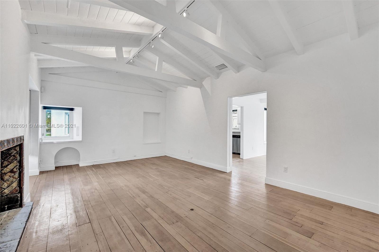 4717 Alton Road Miami Beach, FL 33140 - Photo 5 of 59 a view of an empty room with wooden floor and a window
